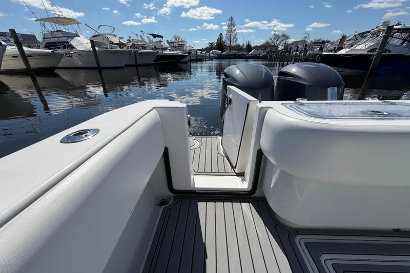 Slide: The Image of 2015 Contender 32 ST boat with dual engines docked at a marina under a clear sky. - 19