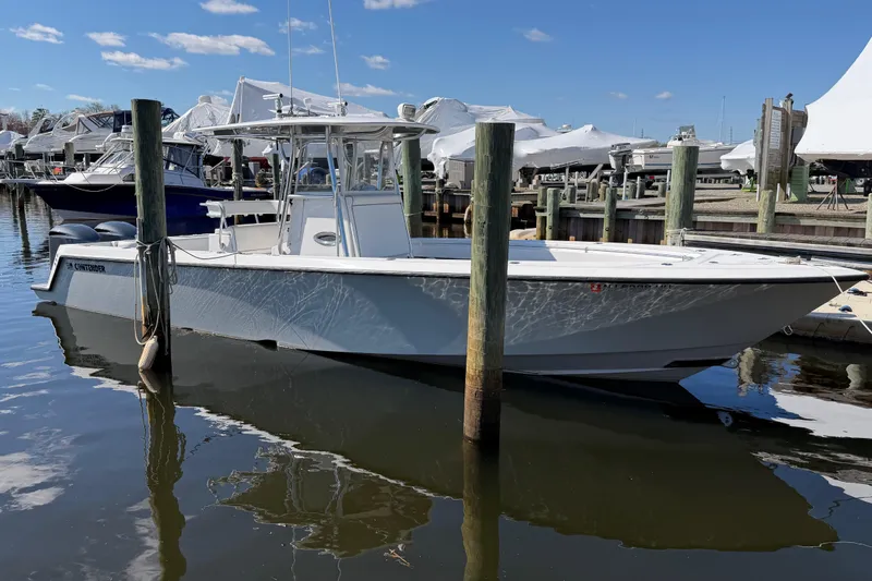 The Image of 2015 Contender 32 ST boat docked at a marina under a clear blue sky. - 4