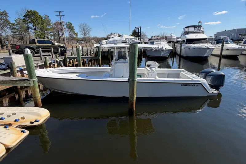 Slide: The Image of 2015 Contender 32 ST boat docked at marina with other vessels. - 6