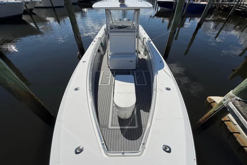 Slide: The Image of 2015 Contender 32 ST boat docked, showcasing sleek design and spacious deck. - 9