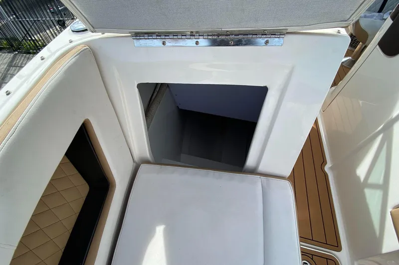 Slide: The Image of 2016 Sea Ray SLX 280 boat interior with cushioned seating and storage compartment. - 2