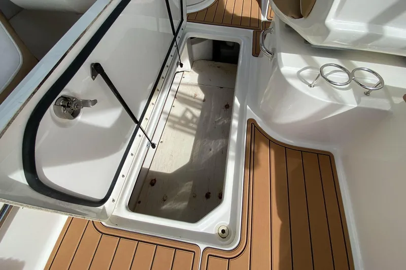 Slide: The Image of Open storage compartment on 2016 Sea Ray SLX 280 boat with teak flooring. - 3
