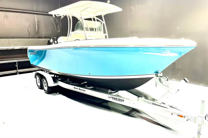 The Image of 2022 Sailfish 242 CC boat on trailer in indoor setting. - 1