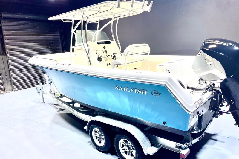 Slide: The Image of 2022 Sailfish 242 CC boat on trailer, blue hull, indoor setting. - 3
