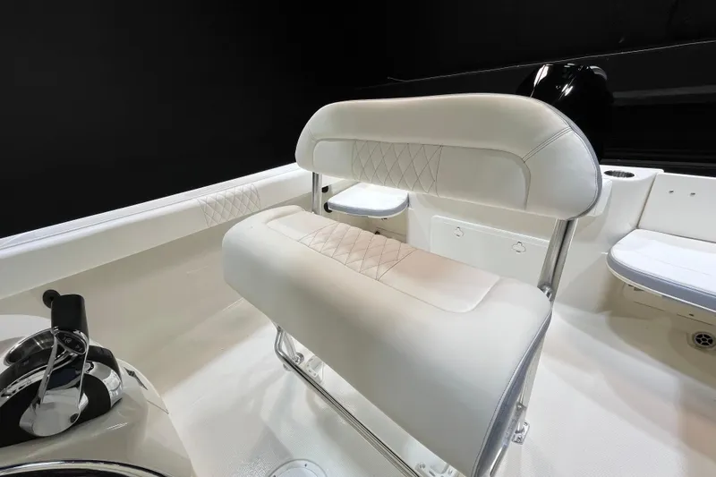 Slide: The Image of 2022 Sailfish 242 CC boat interior with white cushioned seating and steering controls. - 8