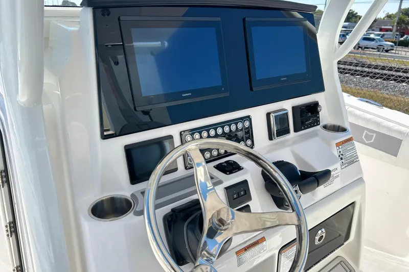 Slide: The Image of 2026 Sea Fox 288 Commander boat dashboard with dual Garmin displays and steering wheel. - 1