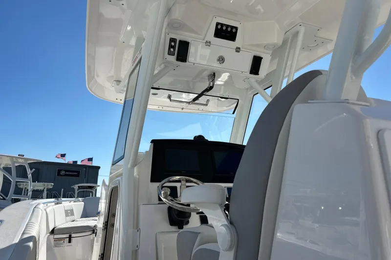 Slide: The Image of 2026 Sea Fox 288 Commander boat interior with steering wheel and dashboard under clear blue sky. - 28