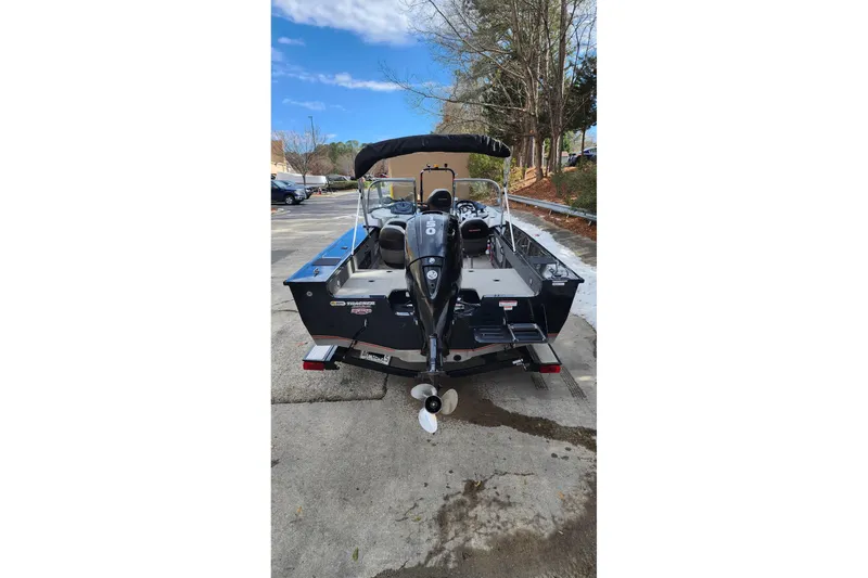 Slide: The Image of 2013 Tracker Targa V-18 WT boat with outboard motor, parked outdoors. - 4