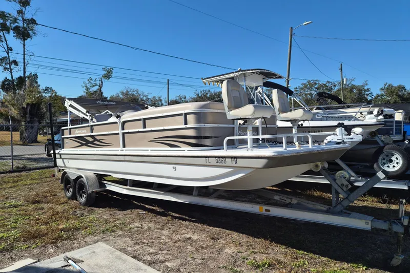 The Image of 2013 Hurricane FunDeck 226 boat on trailer, parked outdoors under clear blue sky. - 1