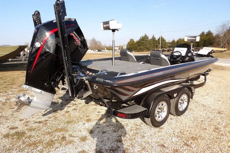 Slide: The Image of 2024 Phoenix 721 ProXP bass boat with powerful outboard motor, parked on gravel. - 9