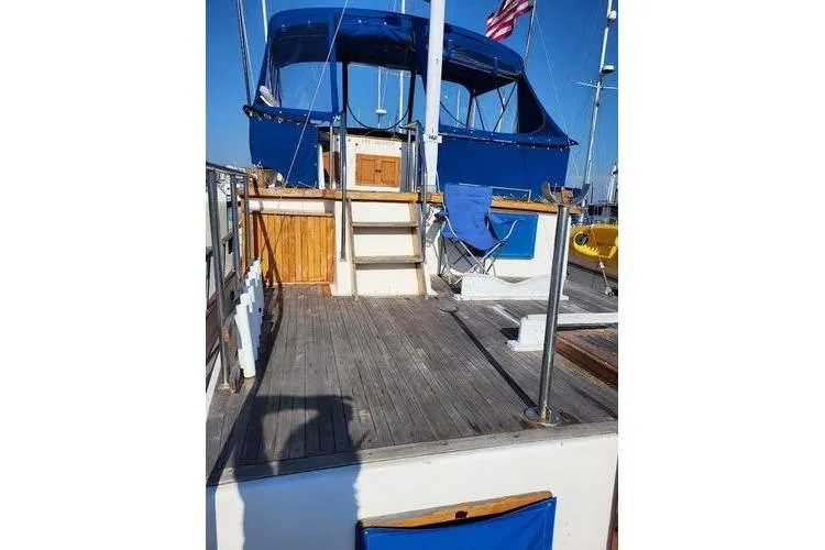 Slide: The Image of 1981 Marine Trader trunk cabin trawler with blue canopy and wooden deck. - 10