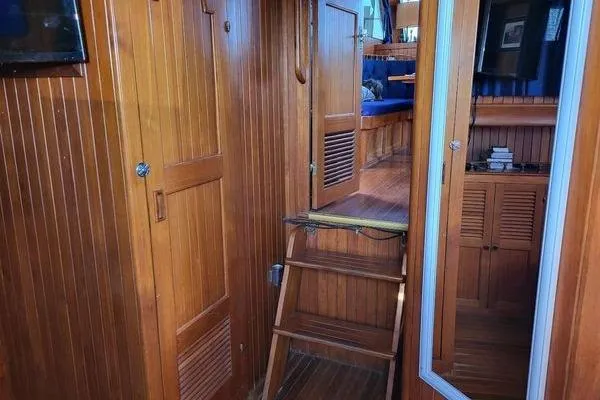 Slide: The Image of 1981 Marine Trader trunk cabin trawler interior with wooden paneling and ladder. - 5