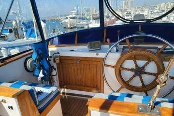 Slide: The Image of 1981 Marine Trader trunk cabin trawler helm with wooden wheel and marina view. - 8
