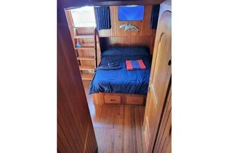 Slide: The Image of 1981 Marine Trader trunk cabin trawler bedroom with wooden interior and cozy bed. - 9