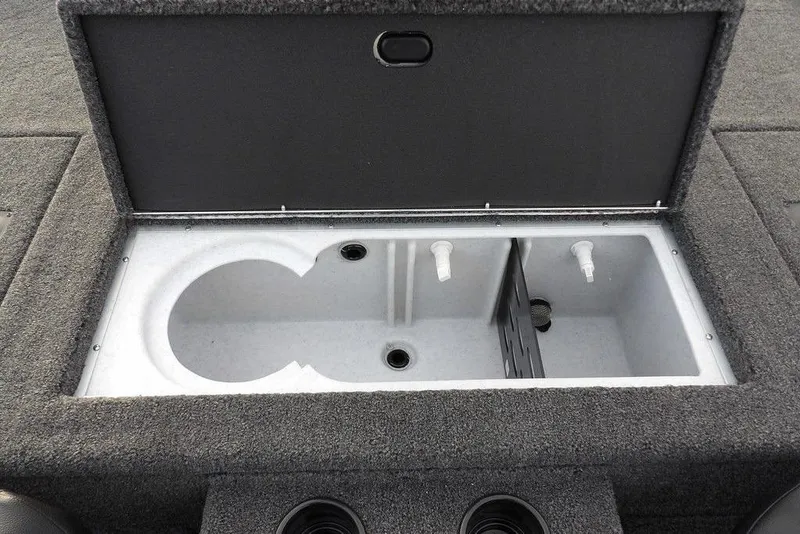 Slide: The Image of Open storage compartment in 2026 Crestliner XFC 189 boat, featuring dual drainage outlets. - 14