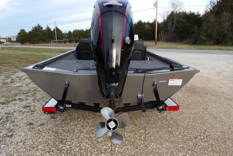 Slide: The Image of 2026 Crestliner XFC 189 boat rear view with outboard motor on gravel. - 3