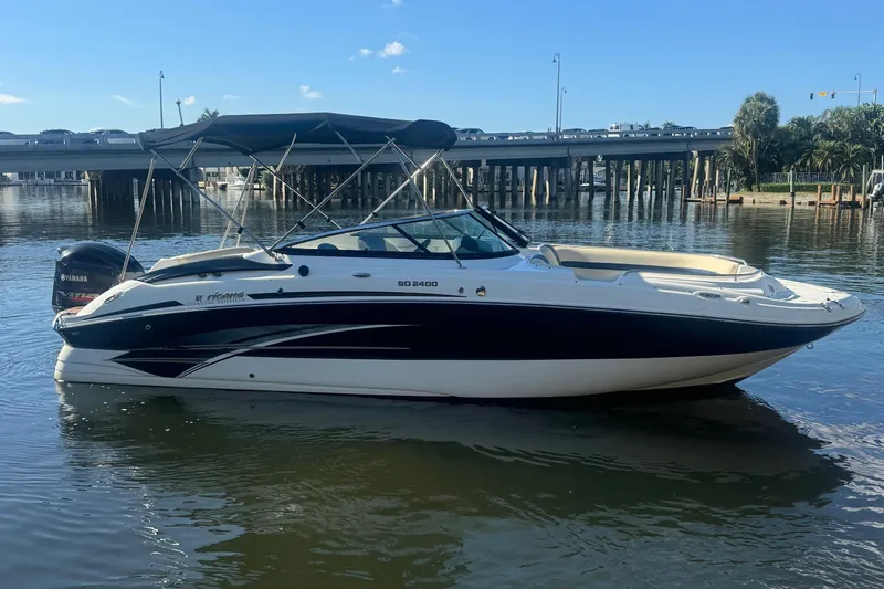 The Image of 2018 Hurricane SunDeck 2400 OB boat on calm water under a clear blue sky. - 1