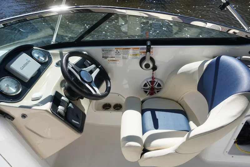 Slide: The Image of 2018 Hurricane SunDeck 2400 OB boat interior with steering wheel and Garmin navigation system. - 11