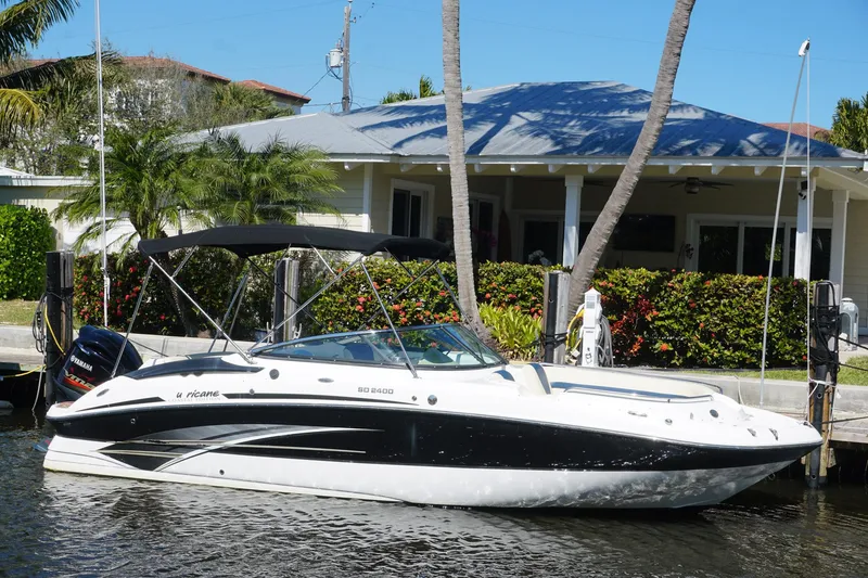 Slide: The Image of 2018 Hurricane SunDeck 2400 OB boat docked by a waterfront house. - 3