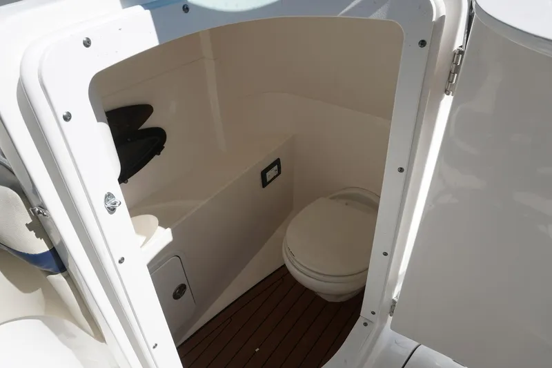 Slide: The Image of 2018 Hurricane SunDeck 2400 OB boat interior with compact marine toilet. - 6