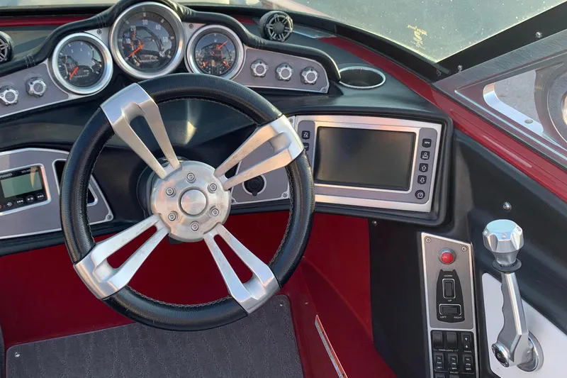 Slide: The Image of 2017 MasterCraft X23 boat dashboard with steering wheel and control panel. - 2