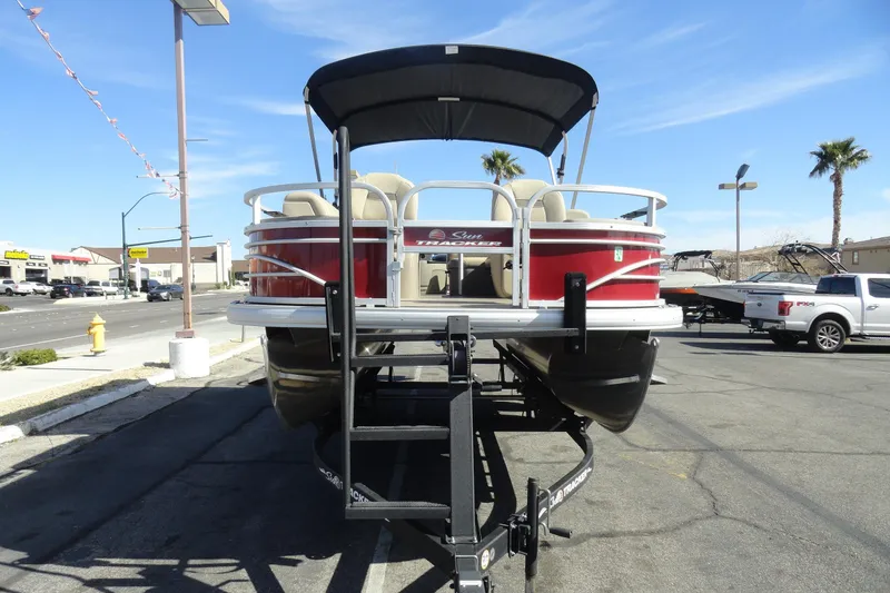 Slide: The Image of 2022 Sun Tracker Fishin' Barge 20 DLX pontoon boat on trailer, parked outdoors. - 3