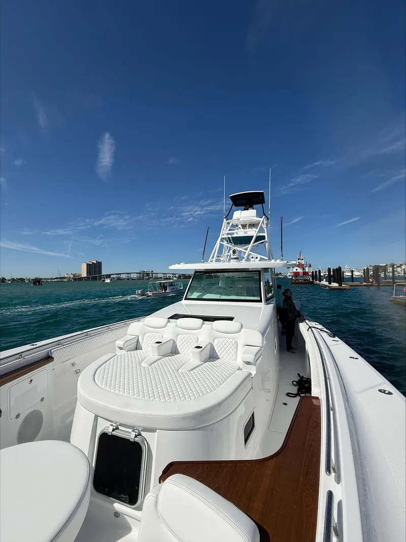 Slide: The Image of 2025 HCB 56 Suenos GIX luxury boat on water, clear sky, marina background. - 2