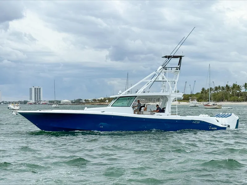 Slide: The Image of 2025 HCB 56 Suenos GIX boat on water, blue hull, overcast sky. - 1