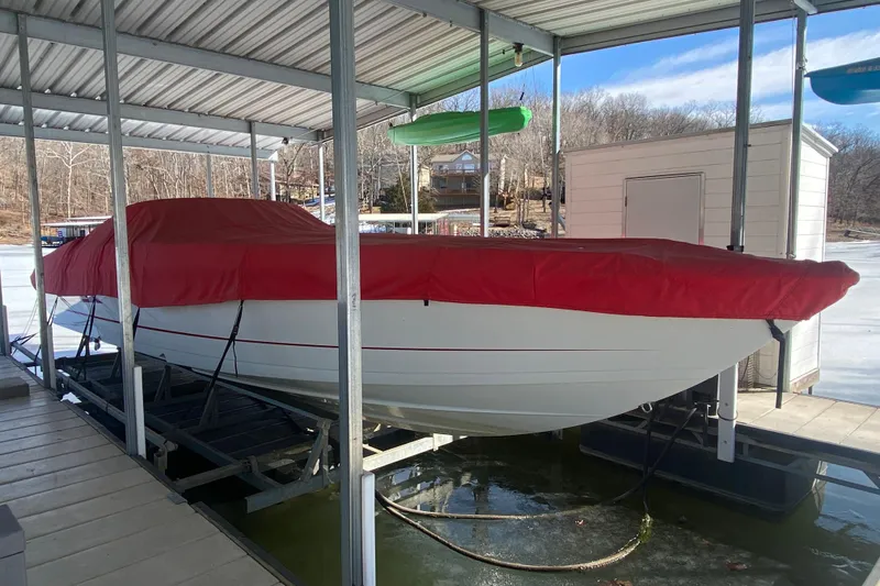 Slide: The Image of 2006 Formula 353 FASTech boat with red cover docked in a sheltered marina. - 36