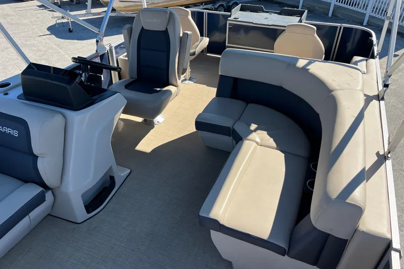 Slide: The Image of 2024 Harris Cruiser 230 pontoon boat interior with plush seating and helm station. - 11
