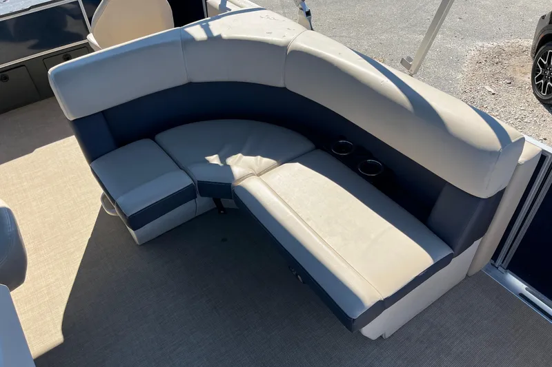 Slide: The Image of 2024 Harris Cruiser 230 boat interior with beige and navy seating, cup holders visible. - 12