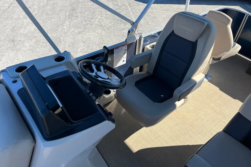 Slide: The Image of 2024 Harris Cruiser 230 boat interior with steering wheel and captain's chair. - 17
