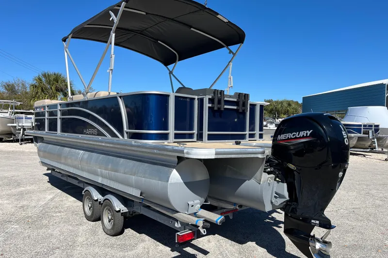 Slide: The Image of 2024 Harris Cruiser 230 pontoon boat with Mercury outboard motor on trailer. - 3