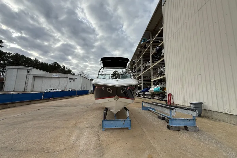 Slide: The Image of 2011 Cobalt 242 boat on dry dock, cloudy sky, storage facility background. - 2