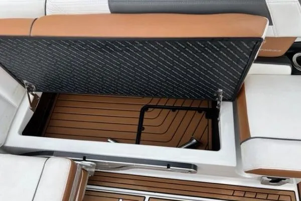 Slide: The Image of 2018 Nautique Super Air Nautique G23 storage compartment with brown and white seating. - 12