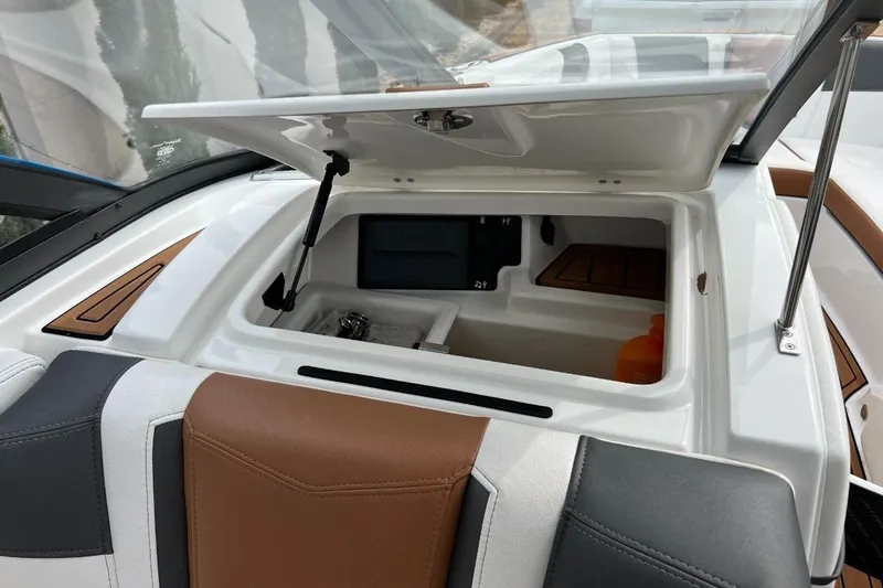 Slide: The Image of 2018 Nautique Super Air Nautique G23 storage compartment with open lid, showcasing interior details. - 14