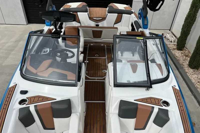 Slide: The Image of 2018 Nautique Super Air Nautique G23 boat interior with brown and white seating, open windshield. - 17