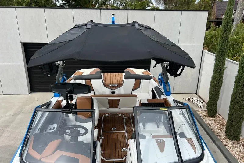 Slide: The Image of 2018 Nautique Super Air Nautique G23 boat with black canopy and luxurious interior. - 18