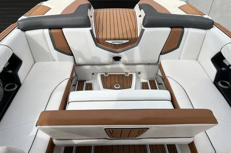 Slide: The Image of 2018 Nautique Super Air Nautique G23 interior with white and brown seating, teak flooring. - 19