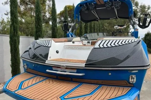 Slide: The Image of 2018 Nautique Super Air Nautique G23 boat with teak deck and blue accents. - 5