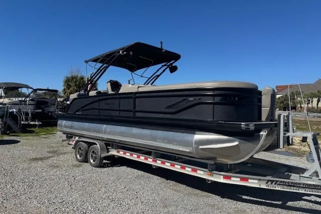 Slide: The Image of 2024 Barletta CORSA 25 QSSA pontoon boat on trailer, sunny day. - 2