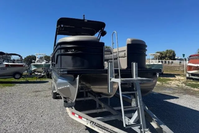 Slide: The Image of 2024 Barletta CORSA 25 QSSA pontoon boat on trailer, parked outdoors. - 5