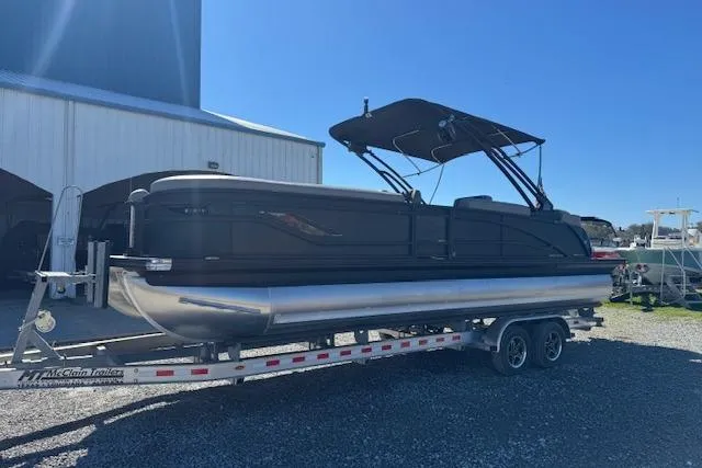 Slide: The Image of 2024 Barletta CORSA 25 QSSA pontoon boat on trailer, parked outdoors. - 6