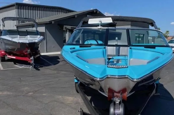 Slide: The Image of 2018 MasterCraft ProStar boat in a parking lot, vibrant blue color, sunny day. - 3