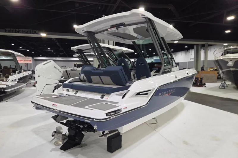 Slide: The Image of 2026 Monterey Elite 25 SD boat displayed at an indoor exhibition hall. - 2