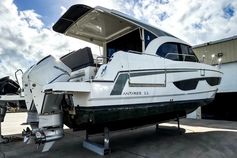 Slide: The Image of 2024 Beneteau America Antares 11 boat with dual Mercury engines, docked outdoors. - 1