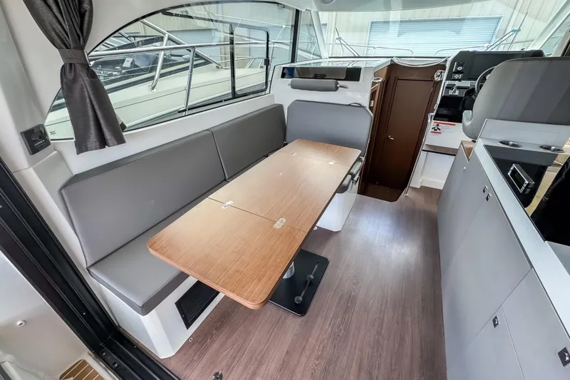 Slide: The Image of 2024 Beneteau Antares 11 interior with modern seating and wooden table. - 11