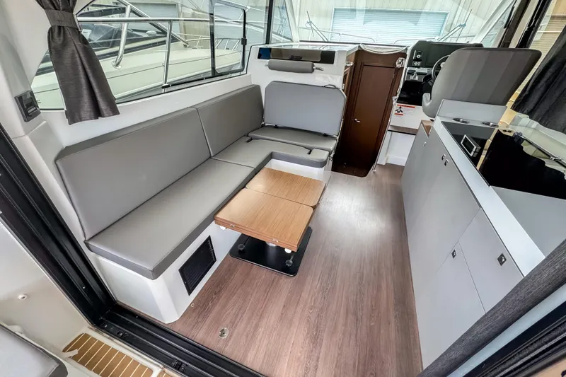 Slide: The Image of 2024 Beneteau America Antares 11 interior with modern seating and kitchenette. - 13