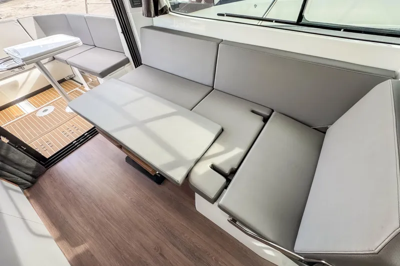 Slide: The Image of 2024 Beneteau Antares 11 interior with convertible seating and modern design. - 14