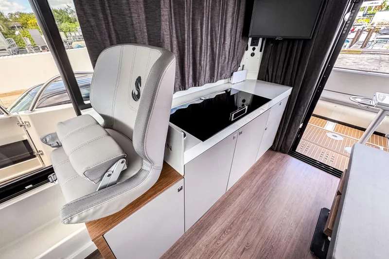 Slide: The Image of Interior of 2024 Beneteau America Antares 11, featuring helm seat and modern cabinetry. - 16